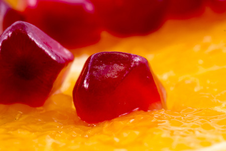 Macro peeled ripe pomegranate fruit with slice of orange fruit for backgroundの写真素材