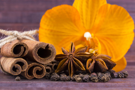 Cinnamon sticks, star anise and orchid on wooden background. Christmas Decorations の写真素材