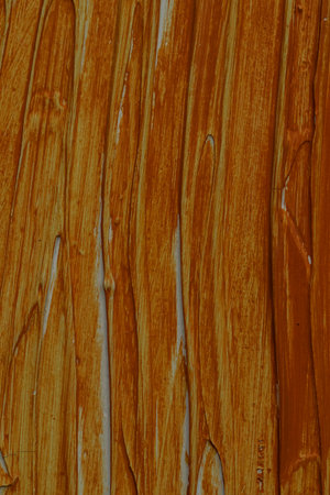 Abstract brown orange paint strokes creating a textured background with vertical lines and brush marksの写真素材