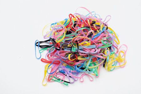 Many colorful elastic hair ties, forming a casual heap on a white background. Representing connection, organization, and daily accessoriesの写真素材