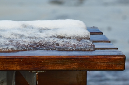 wooden bench with snow in la speziaの写真素材