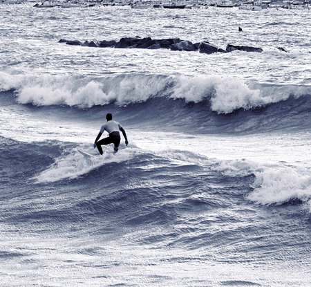 a surfer surf a wave in italy