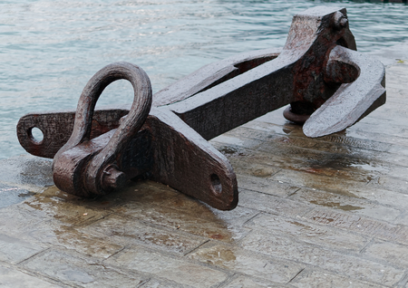 detail of big rusty anchor near the sea