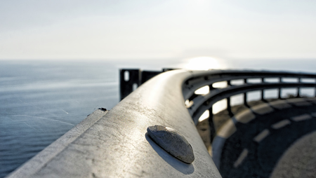 detail of metal guard rail under a cloudy skyの写真素材