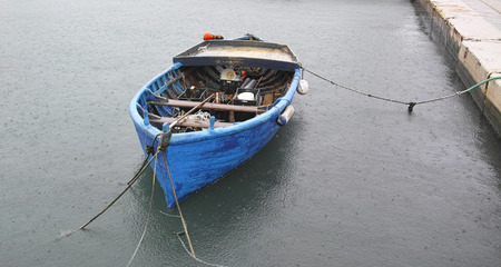 detail of fishing boat in a harbour during rain