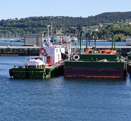detail of green antipollution barge in the harbpour of la speziaの写真素材