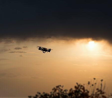Drone hovering in the sky during sunset