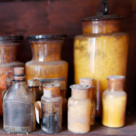 A bottle of poison on a background of old medical, chemistry and pharmacy glass. Chemistry and...