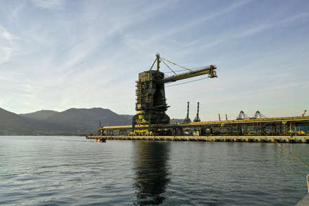 massive harbor crane in a sea port for loading charcol for big electrical power plantの写真素材