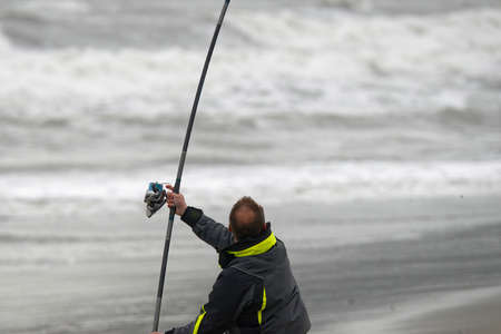 angler fisherman in surfcasting at the beach