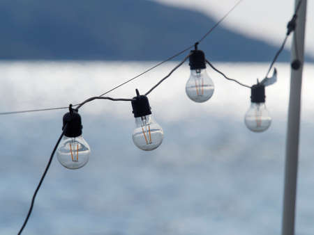 outdoor party string lights hanging in backyard on green bokeh background with copy spaceの写真素材