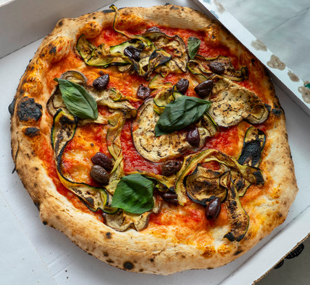 Side view on vegetable pizza with pepper and tomatoesの写真素材