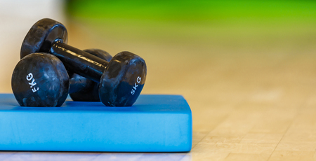 black insulated dumbbells for aerobics and blondes on a blue matの写真素材