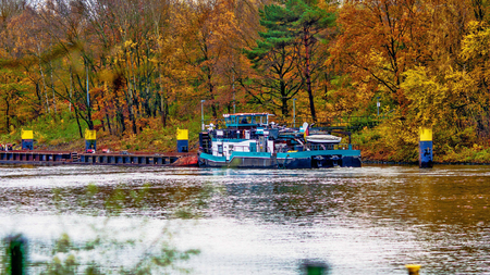 all the colors of autumn by the river, the ship moored to the shoreの写真素材