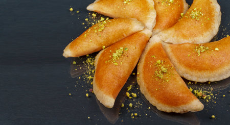 Qatayef, Traditional Arabic Ramadan Sweets with pistachio on black background,top viewの写真素材