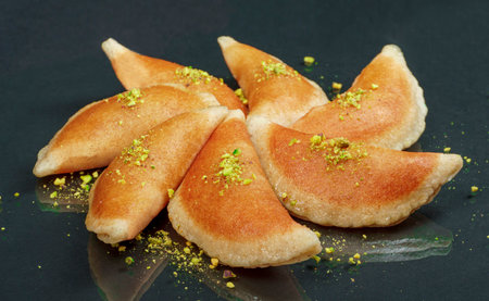 Qatayef, Traditional Arabic Ramadan Sweets with pistachio on black background,side viewの写真素材