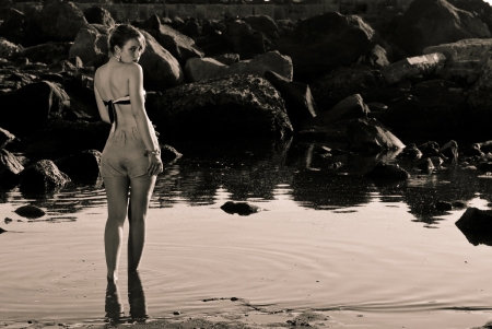 Vintage girl walking in the water looking youの写真素材