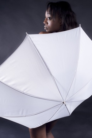 Black woman covered by white umbrellaの写真素材