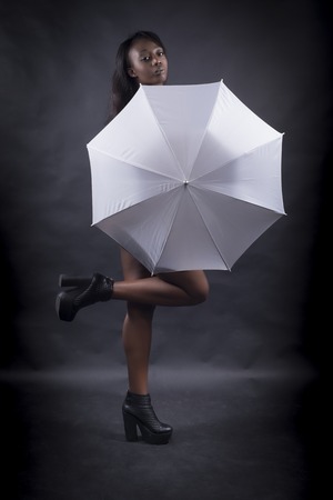 Black woman covered by white umbrellaの写真素材