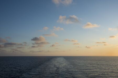Colorful sunset on the sea with wake of the shipの写真素材