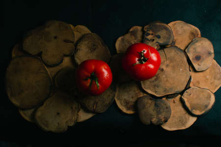 Two red tomatoes on a black background, the view from the topの写真素材