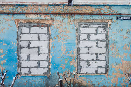 Two walled-up windows in a blue houseの写真素材