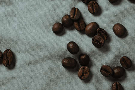 Coffee beans scattered on a white tablecloth