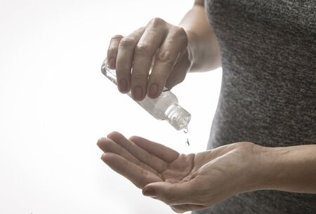 person on white background disinfecting hands applying antibacterial gel