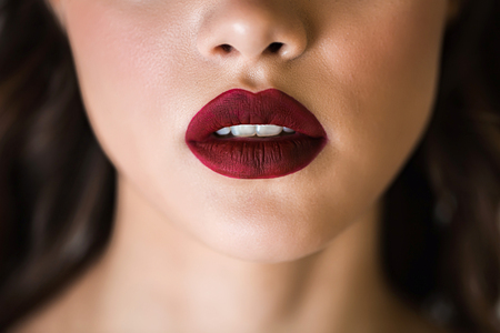 Sensual red woman lips. Half open lips. Close up face of a woman with clean skin. The concept of cosmetics, care, beauty, fashion.の写真素材