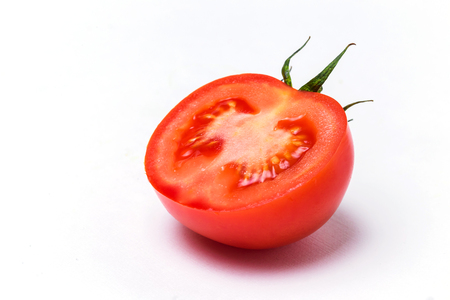 Closeup of red sliced fresh tomato on white isolated backgroundの写真素材