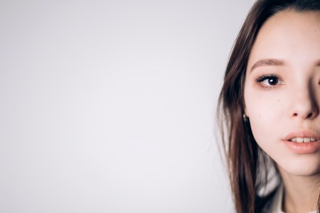 Beautiful woman half-face on white background, copy space, horizontal. Natural beauty, skin care,...