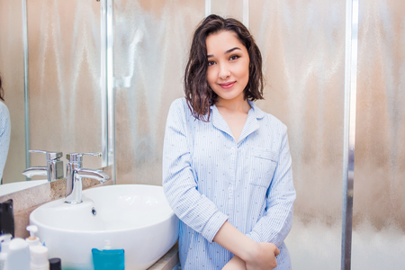 Young smiling woman in the bathroom after a showerの写真素材