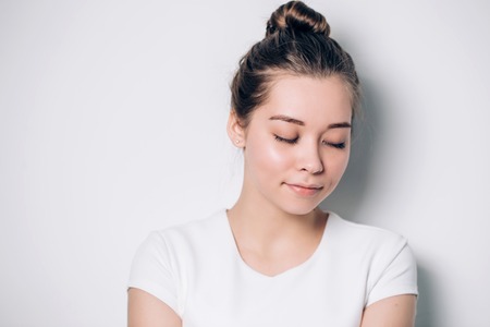 Close up smiling girl in in white t-shirt, eyes closed.の写真素材