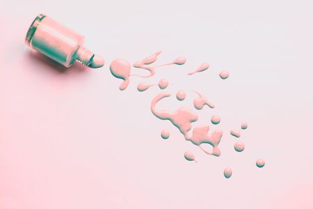 Bottle of pink pearl nail polish with enamel drop samples isolated on light background. Manicure, pedicure, cosmetics concept.の写真素材