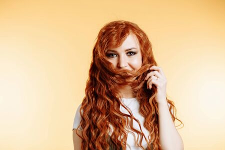 Head shot of cute playful fun woman with green eyes, red long hair, fresh skin long lashes rejoicing...
