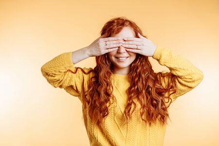 Emotional happy woman covering her eyes with hands going to see surprise by her boyfriend. Portrait...