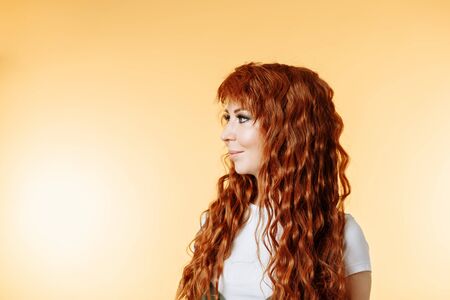 Studio shot of attractive woman isolated on yellow background with copy space for text. Caucasian...