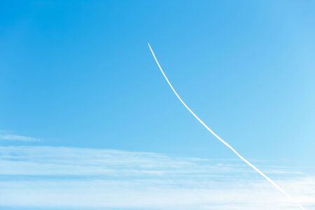 Beautiful white track of the plane on the blue sky