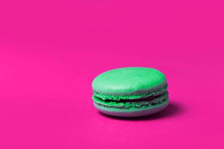 Close up of green sweet macaroon on pink background, selective focusの写真素材