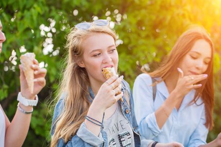 Close up photo of young beautiful women eating ice cream on a summer dayの写真素材