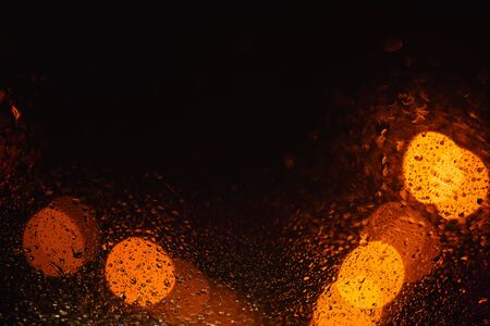 Beautiful black abstract background with yellow bokeh with drops. Texture for copy spaceの写真素材
