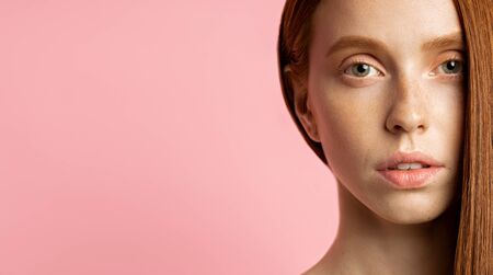 Close up of beautiful young woman's face with clean perfect skin. Portrait of beauty model with no make up over pink background with copy space. Spa, skin care, cosmetology, cosmetic and wellness.の写真素材