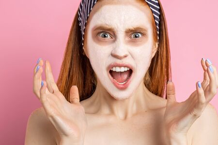 Beautiful woman with facial mask on pink backgroundの写真素材