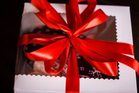Christmas gifts with red bow and christmas illuminations on a black background. holidays, new year,...
