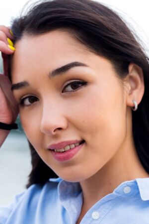 Close up of the face of a beautiful smiling brunette womanの写真素材