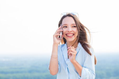 Young happy student girl talking on smartphone and laughing. Positive emotions, youth, College conceptの写真素材