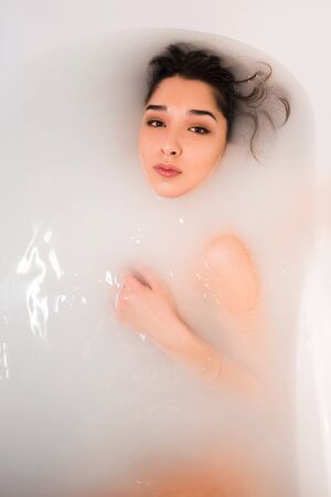 Attractive girl takes a bath with milk. Spa treatments for skin rejuvenationの写真素材
