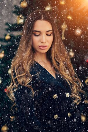 Holidays, celebration and people concept - young woman in elegant dress over christmas interior background. Winter, snow. Holiday, New year, happiness conceptの写真素材