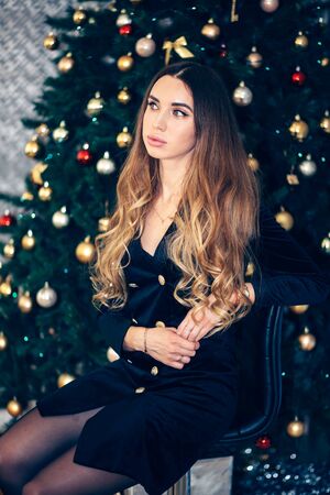 Christmas, fashion concept. Beautiful charming woman in evening dress, looking to the sideの写真素材