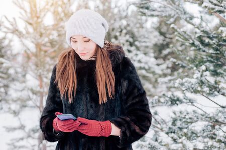 a woman using a smartphone in winterの写真素材